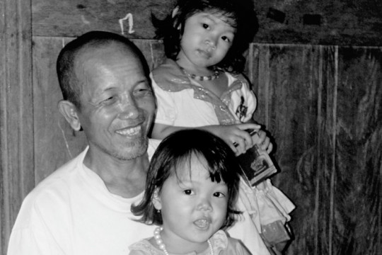 Pak Imis bersama dua dari 12 cucunya. © Budi Kurniawan