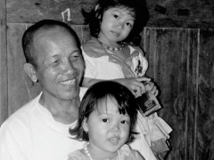 Pak Imis bersama dua dari 12 cucunya. © Budi Kurniawan